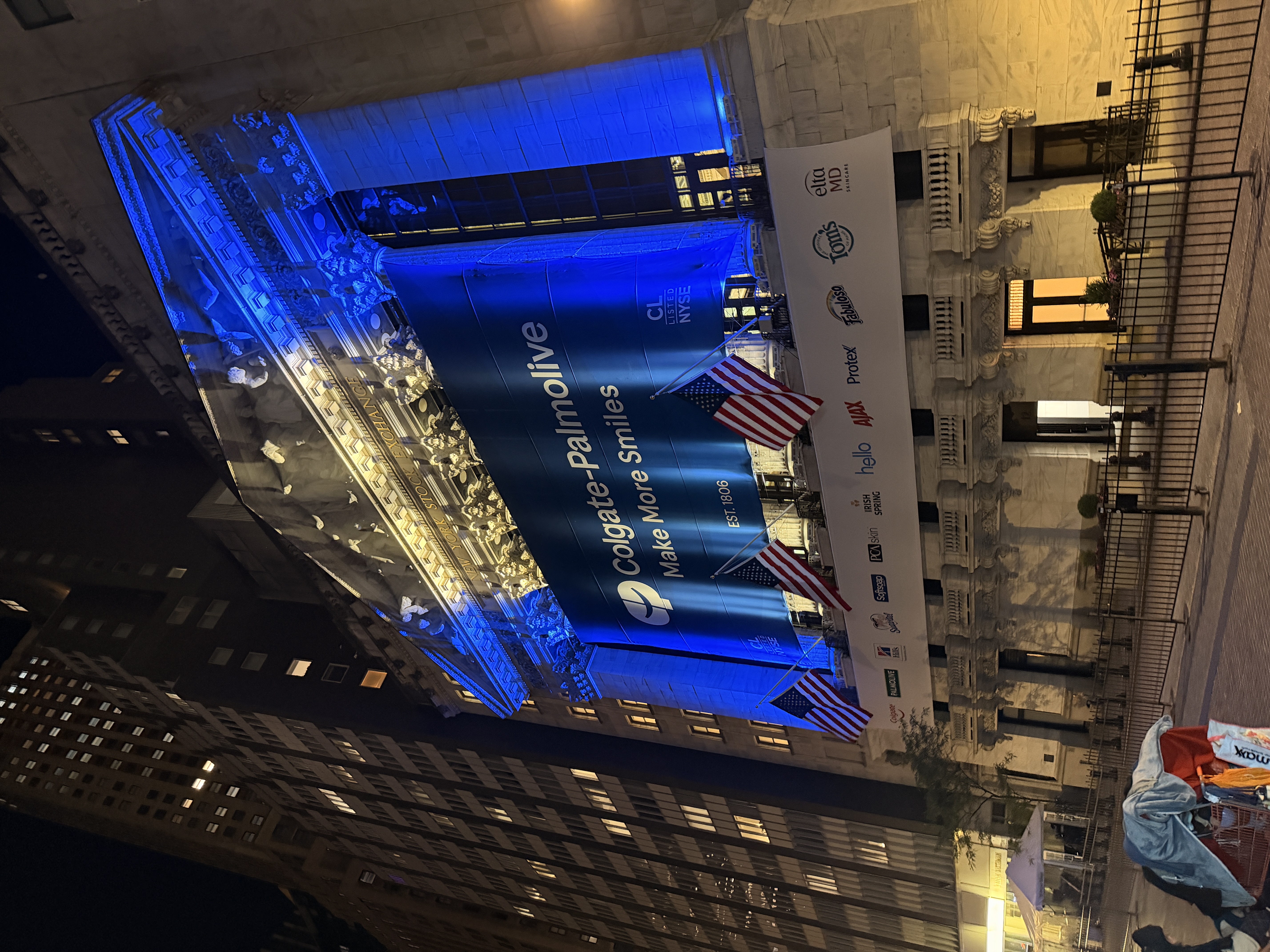New York Stock Exchange lit blue at night with American flags
